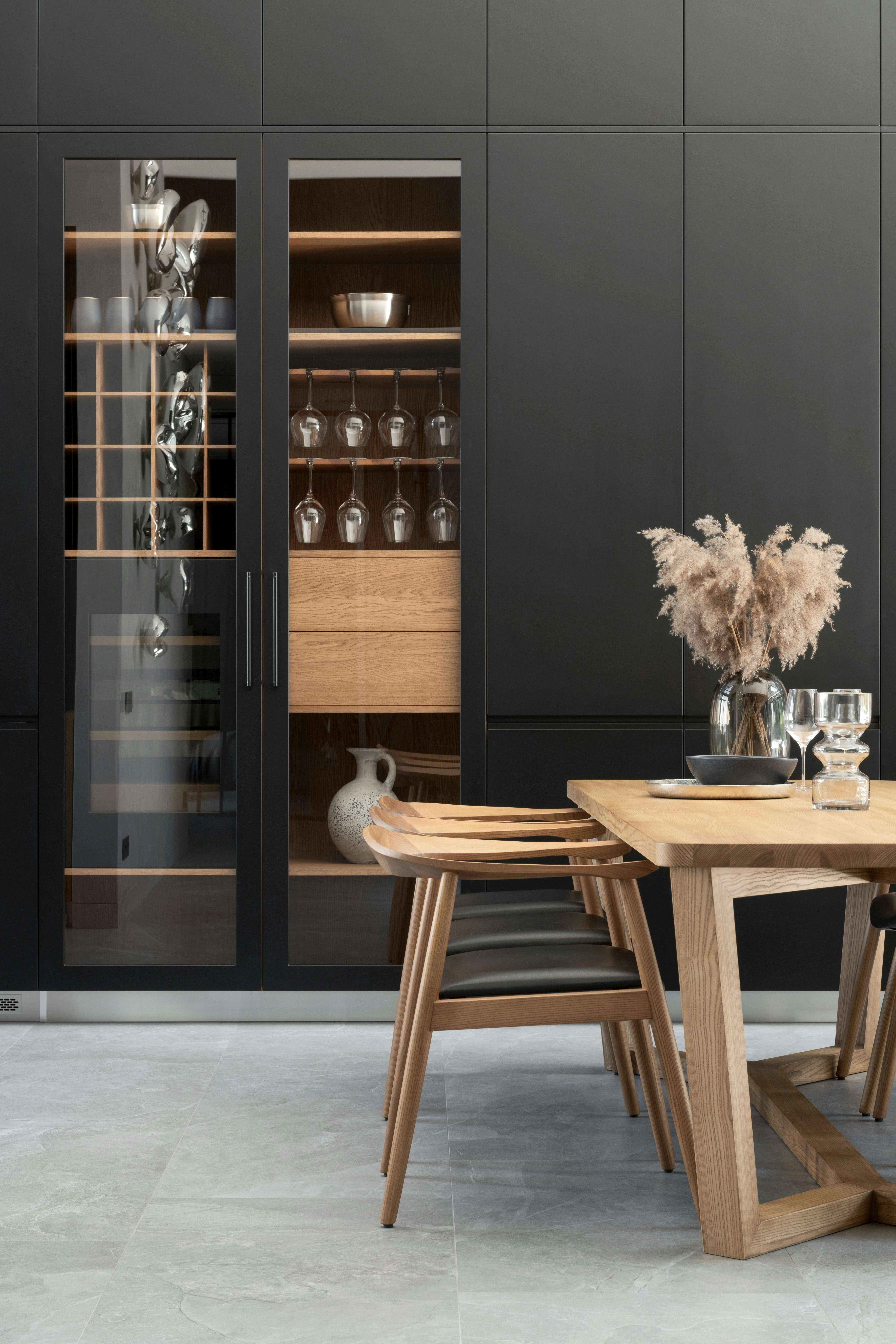 Black leather journal with silver steel disc binding resting on wooden shelf with machined steel pen.